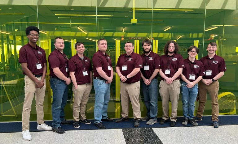 security dawgs members in front of a green wall
